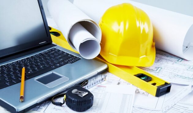 Ordinador, casc, plànols i altres eines de construcció