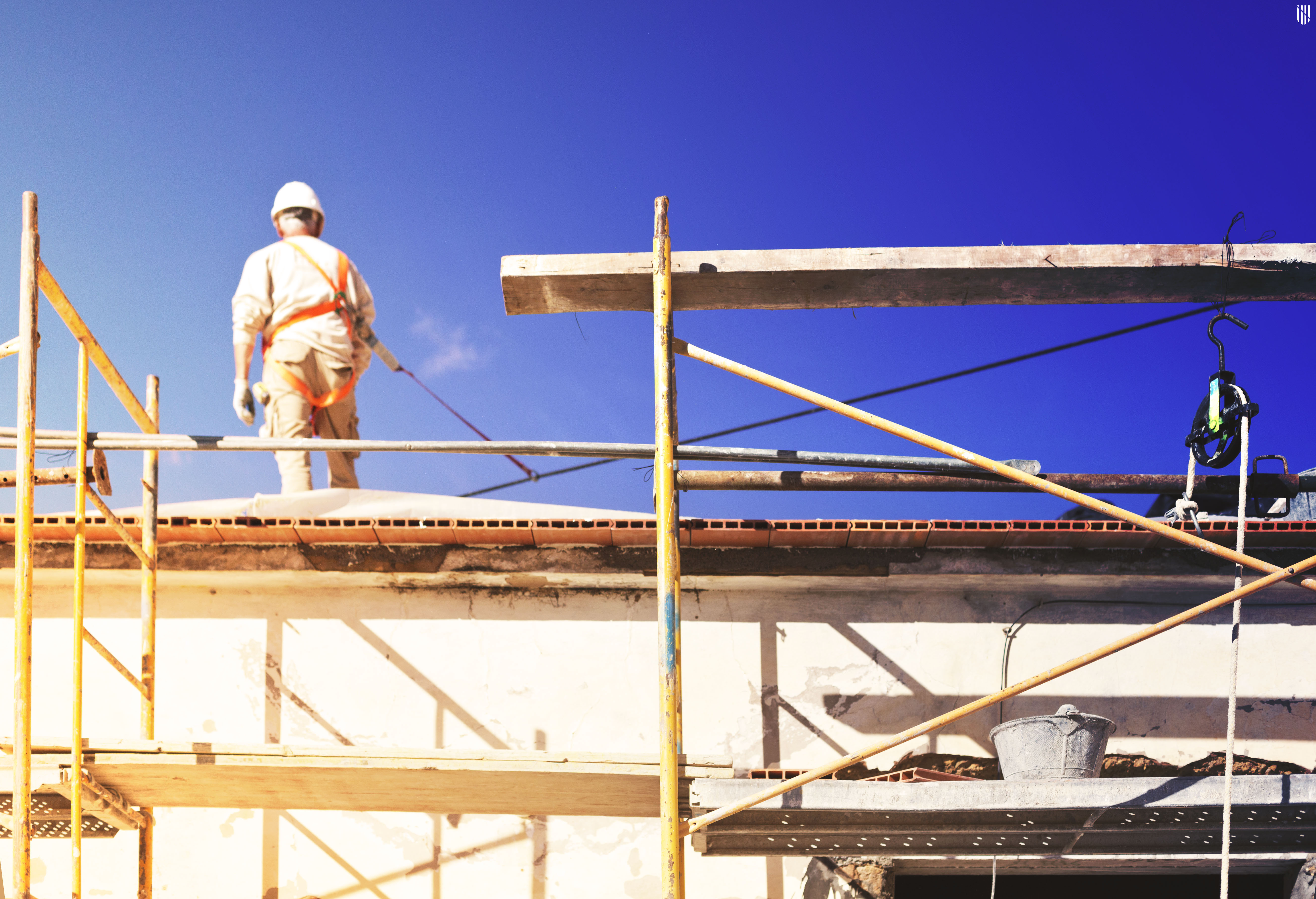 Habitatge amb andamiage a la façana i operari 