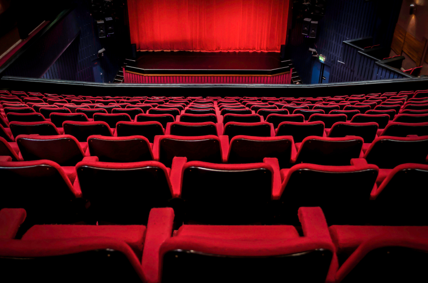 Imagen en tonos rojos de sillas y escenario