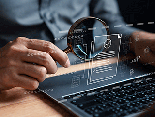 Mano con una lupa sobre un ordenador