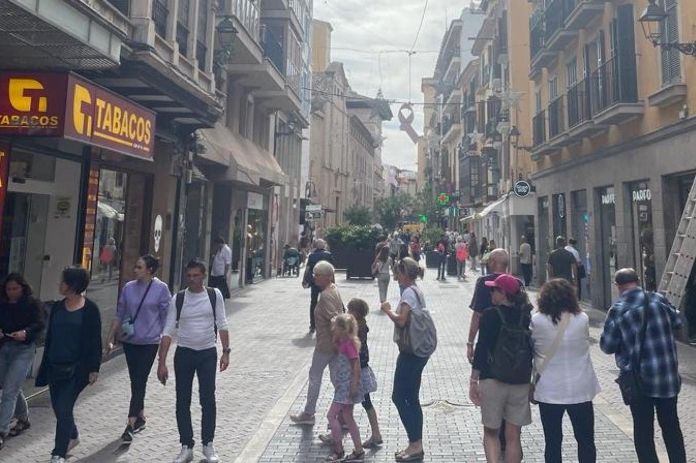 Gent passejant per un carrer comercial