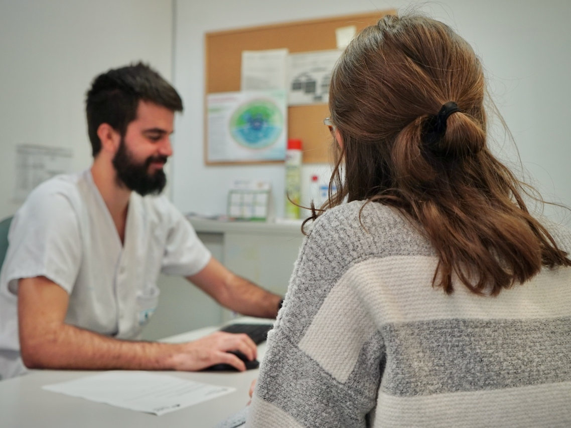 Un metge atén a una pacient a una consulta.