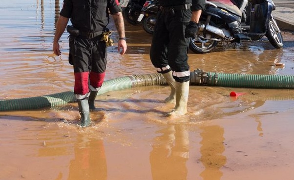 Dos bombers buiden d'aigua una carretera d'Eivissa.