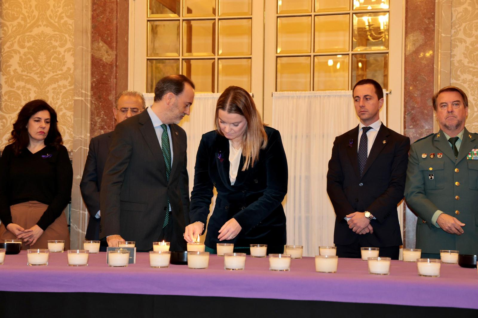 La presidenta Prohens encén una espelma en homenatge a les dones víctimes de violència de gènere, durant l'acte organitzat pel Parlament.