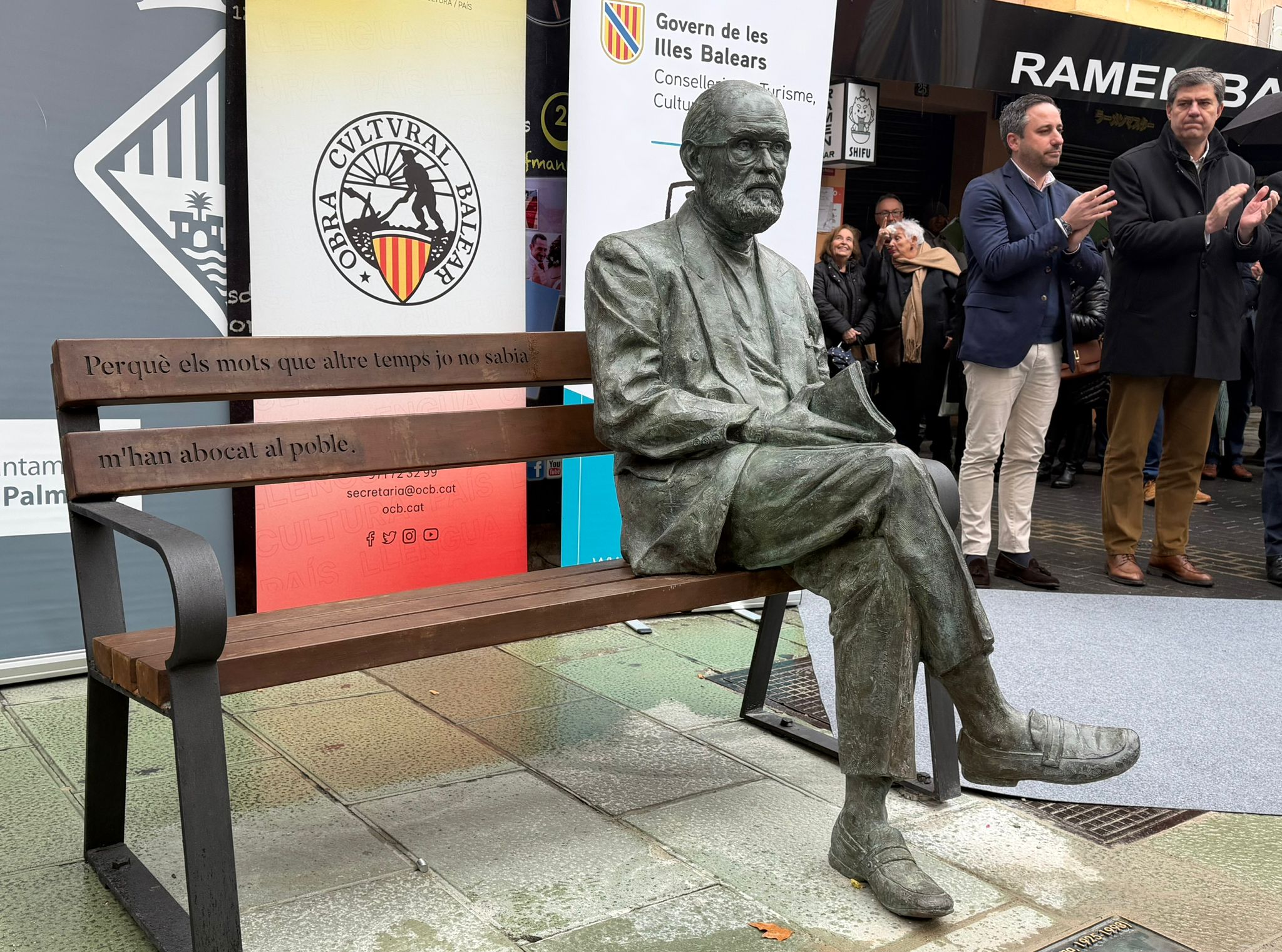L'escultura de Josep Maria Llompart el representa assegut en un banc, en una actitud propera i accessible, al carrer Oms cantonada amb Missió.
