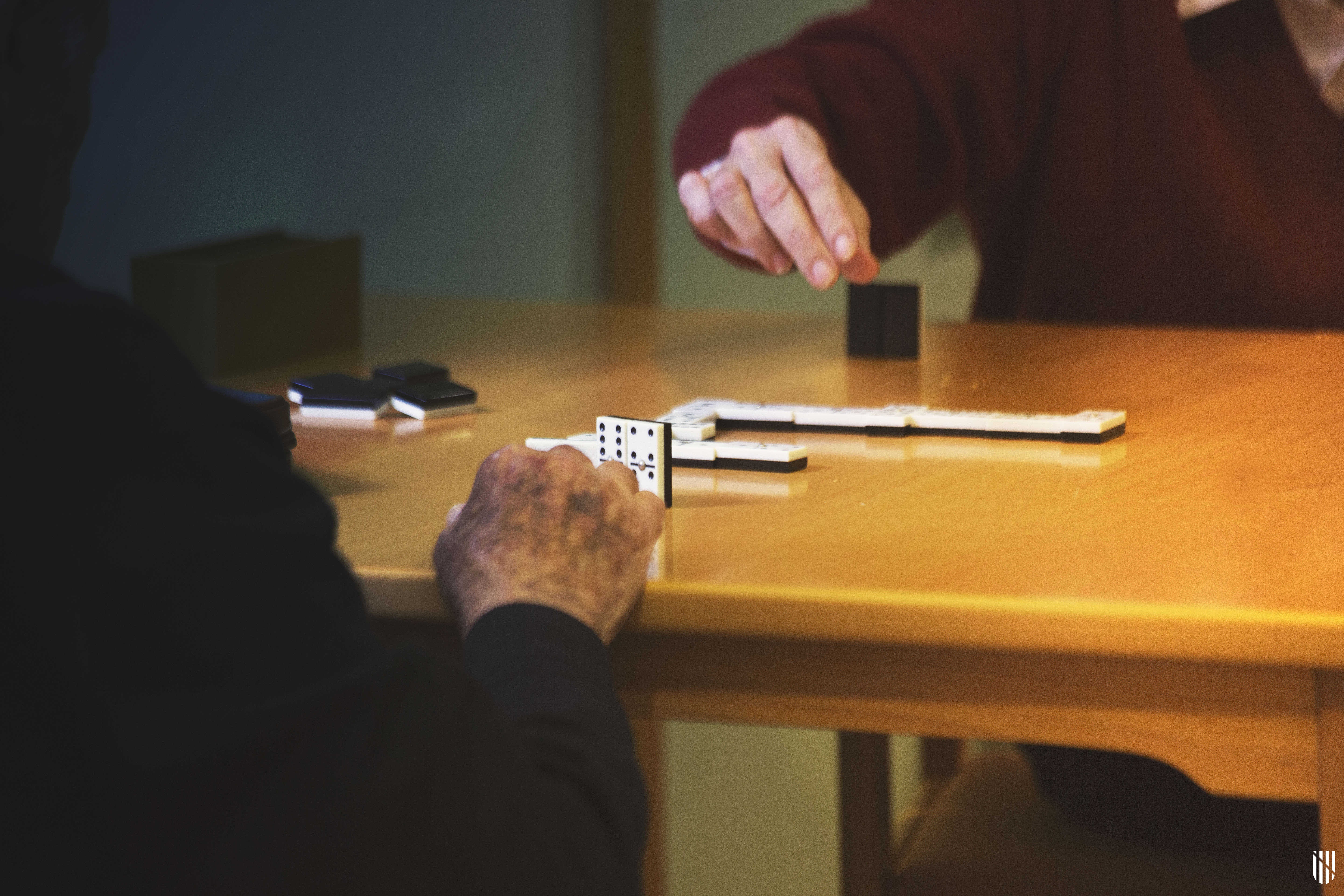 Dues persones grans jugant a domino a un centre de dia