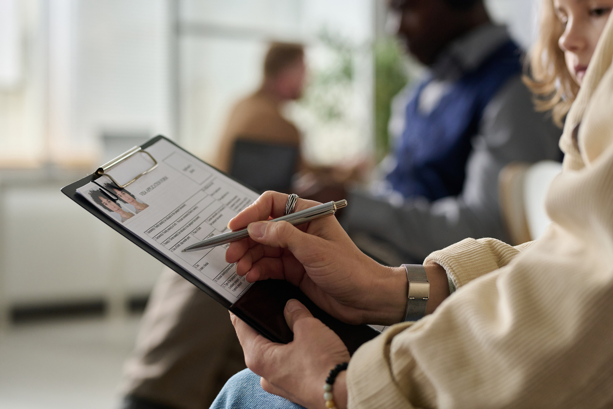 Una dona omple un formulari a una sala.