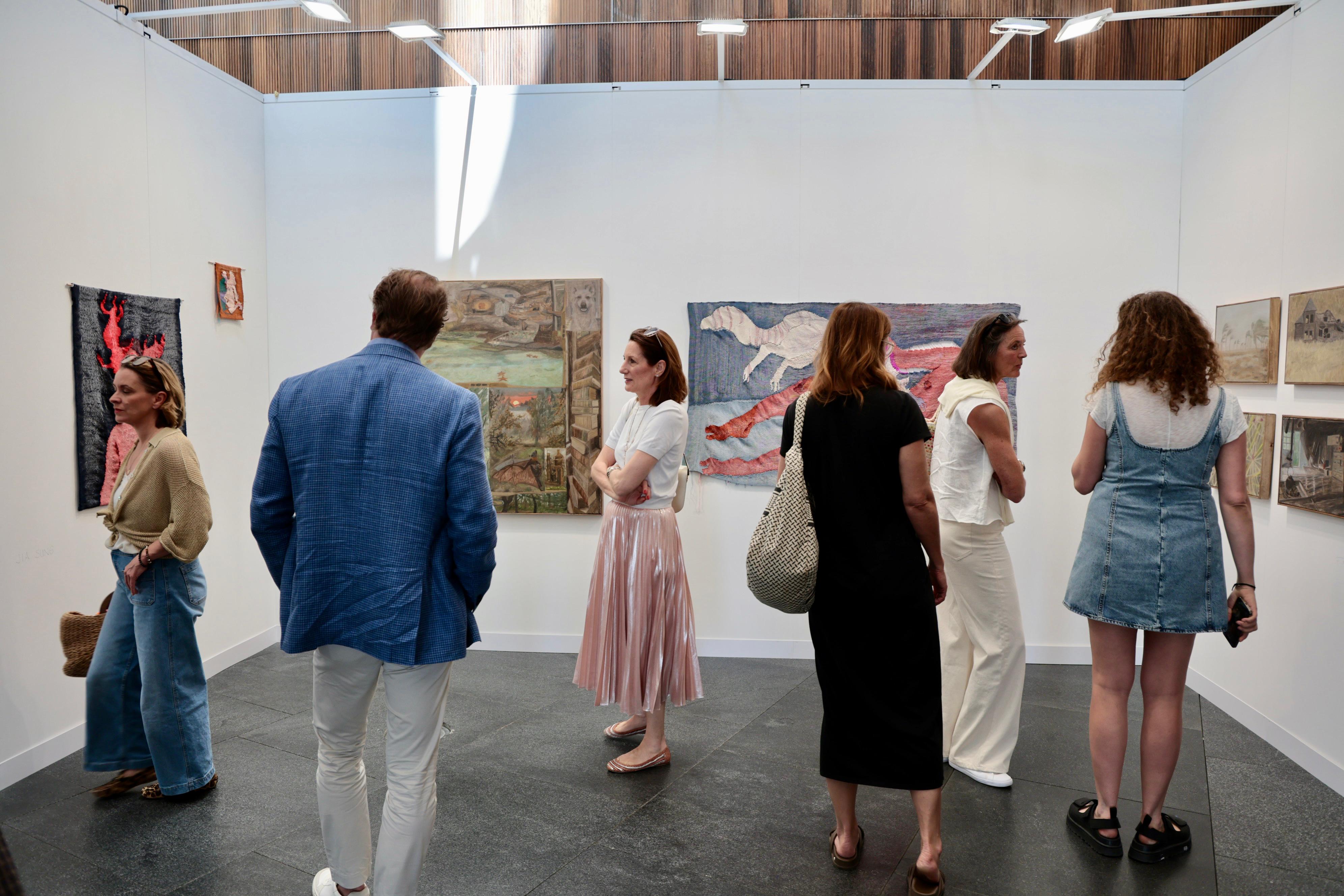 Visitants d'Art Cologne Mallorca observant pintures d'un dels estands.