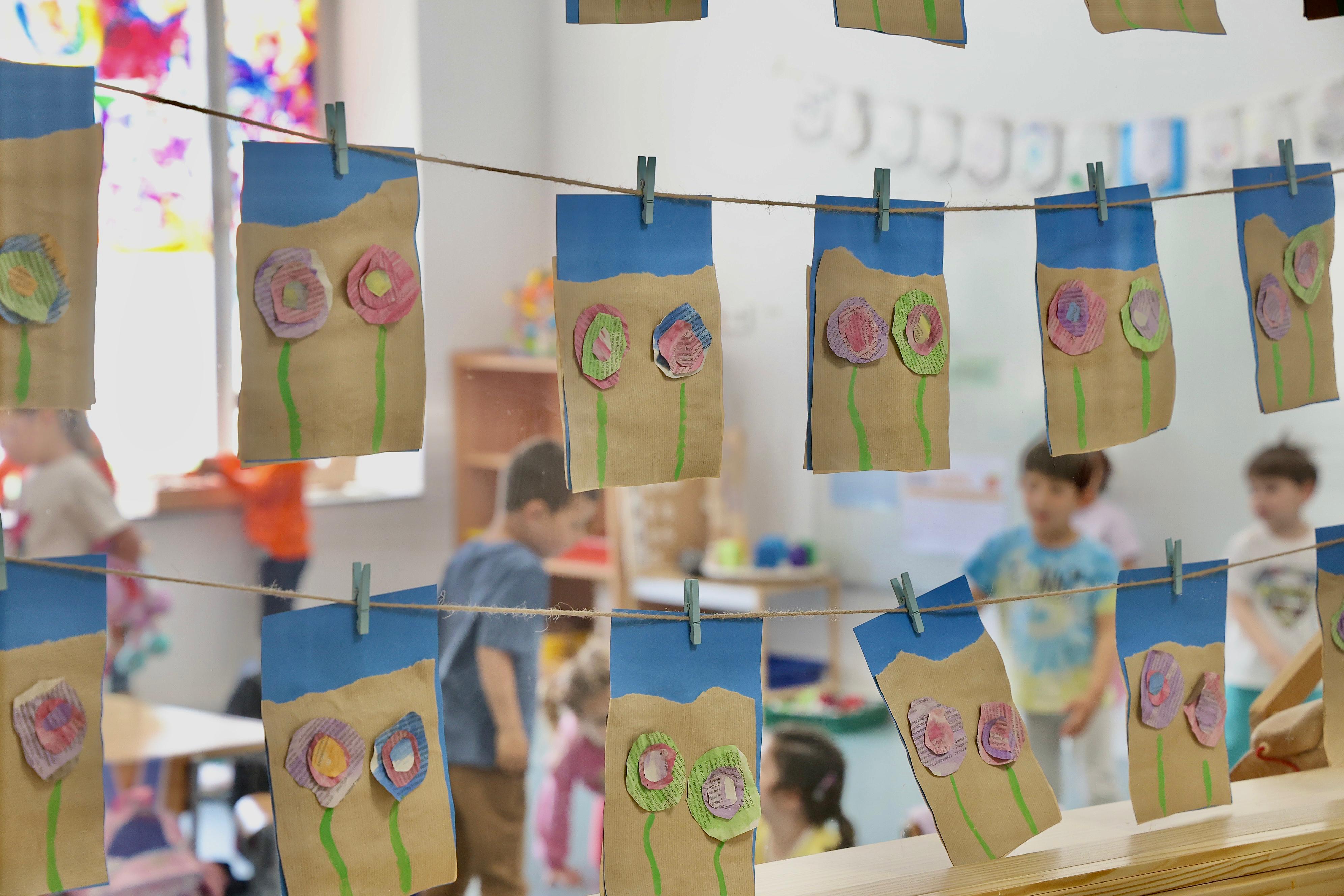 Manualitats infantils penjades dins una aula