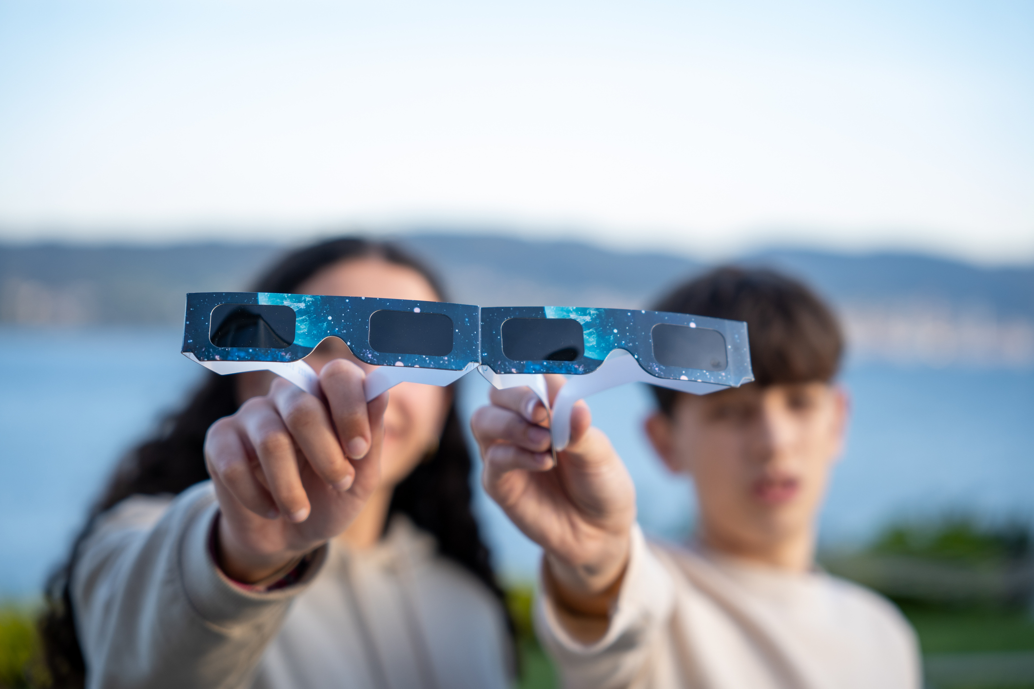 Dos adolescents mostren unes ulleres per veure l'eclipsi.