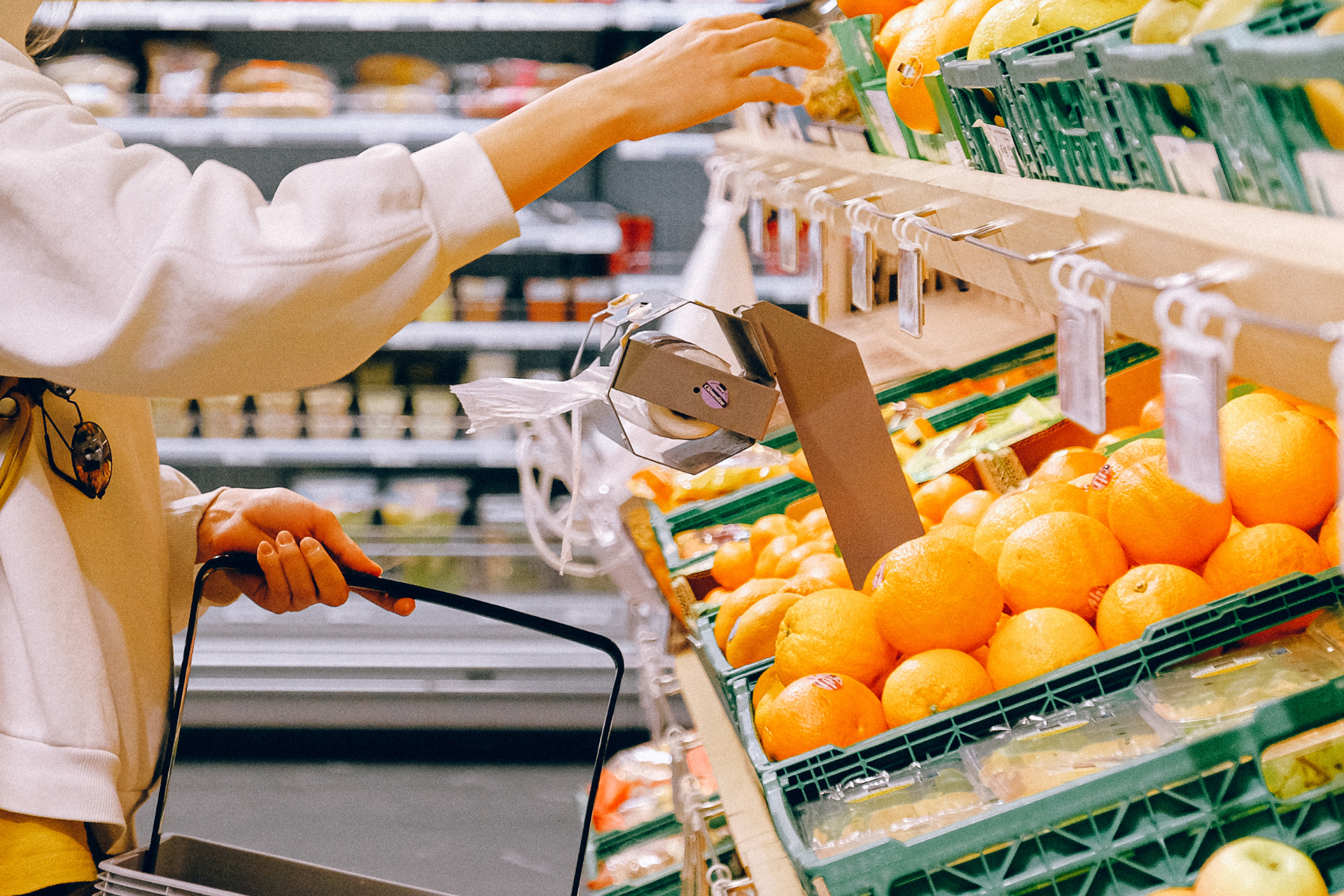 Una dona tria fruita a un supermercat